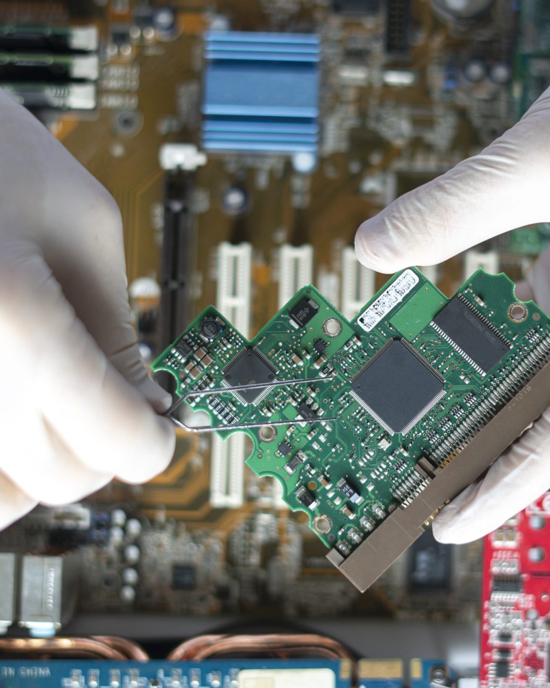 the scientist hands in gloves work with a circuit board in laboratory, close up view