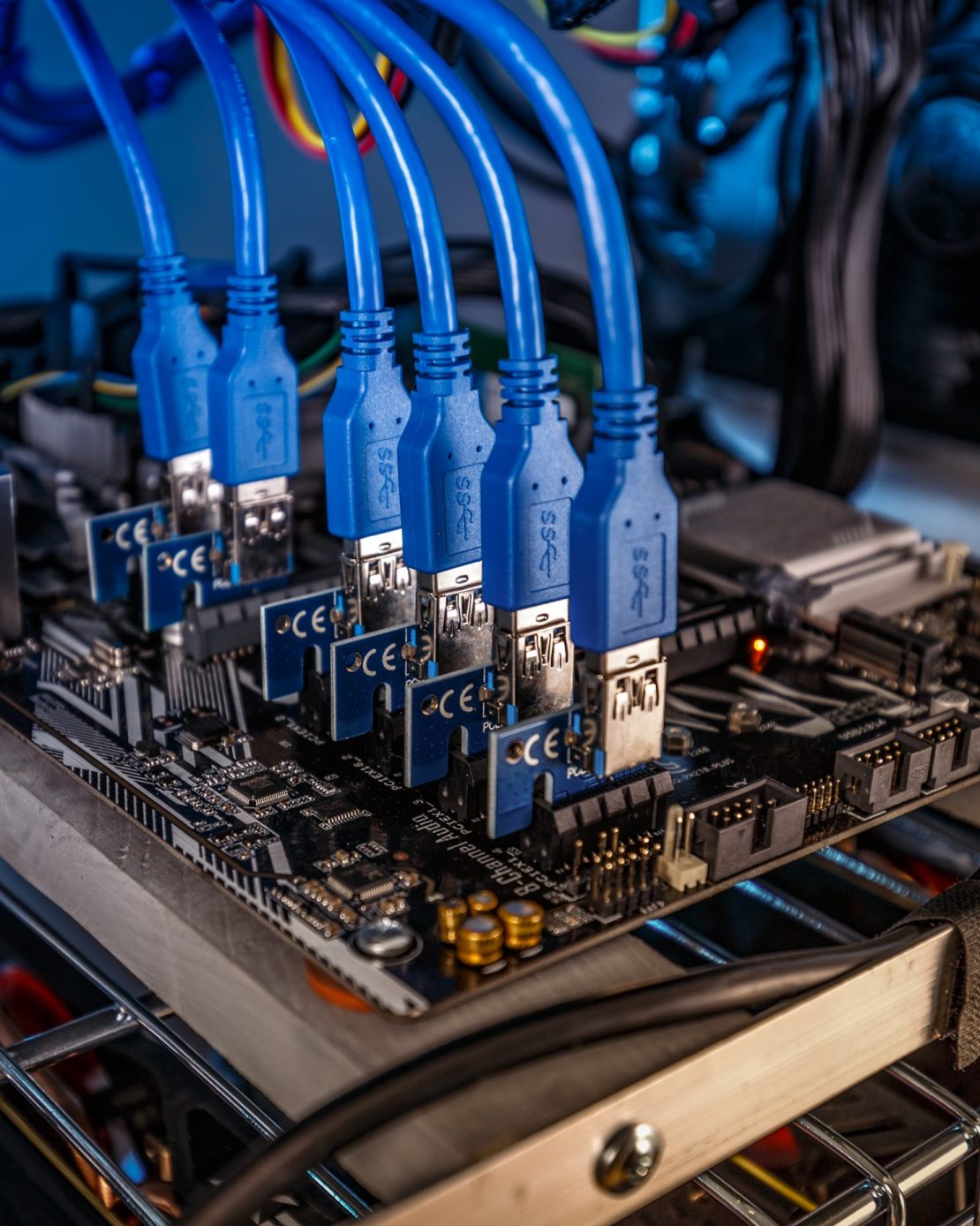 Cryptocurrency mining rig PCIe riser extenders plugged to motherboard